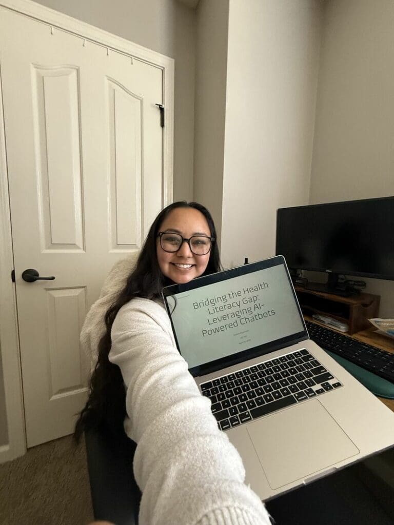 Nadine Miyamoto holding up a laptop for her capstone in the online Master of Health Informatics program