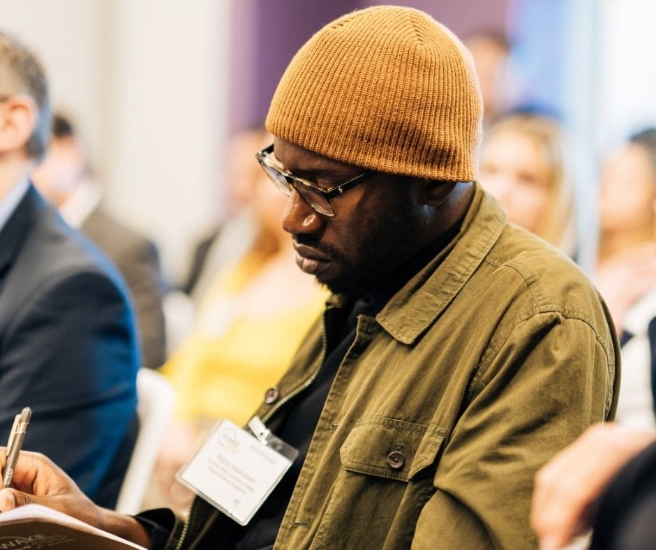 Wake Forest SPS student writing in a notebook at a panel discussion