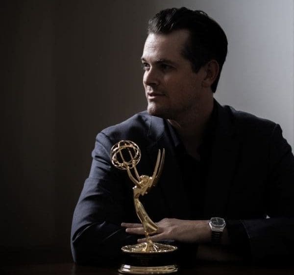 Max Fox sits behind his Emmy trophy